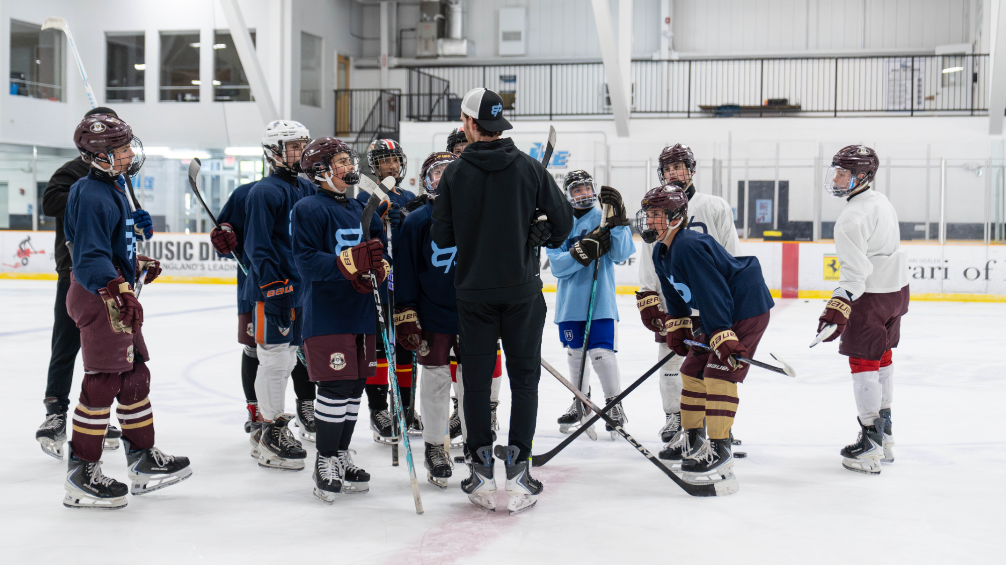 Coach addressing a group of young players on the ice